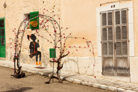Decoration with a girl on a swing made of some tree branches on "Costitx en Flor" (Costitx in bloom) Flower Fair, Majorca, Spainの写真素材