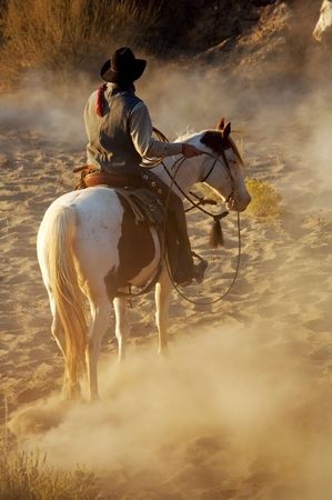 Cowboy riding his horse in the desertの写真素材