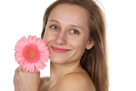 Pretty blond with a smile holding a pink gerber daisy on white backgroundの写真素材