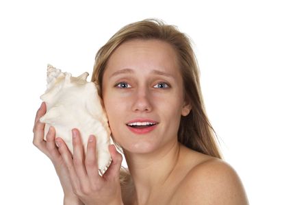 Beautiful blond listening to secrets from a seashellの写真素材