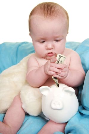 Up Close of cute baby putting money in a piggy bankの写真素材