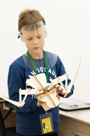 Boy wearing a protective screen with a movable wooden mock-up of a bird skeleton at a children's...