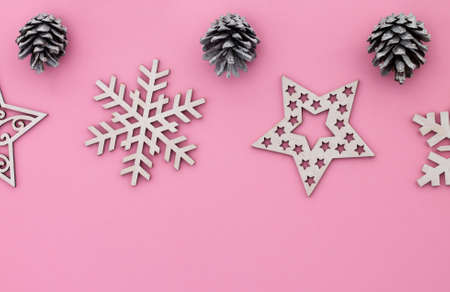 Christmas and New Year. Pink flat lay frame with snowflakes, Christmas toys and cones. Copy spaceの写真素材