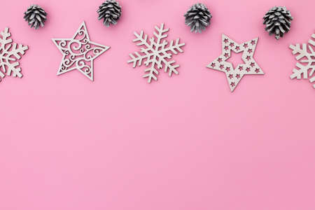Christmas and New Year. Pink flat lay frame with snowflakes, Christmas toys and cones. Copy spaceの写真素材