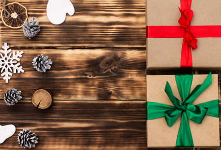 Christmas and New Year. Wooden dark flat lay frame with gifts, Christmas toys and cones. Copy spaceの写真素材