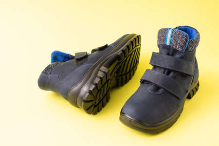 Dark blue autumn men's children's boots on a yellow background, copy spaceの写真素材