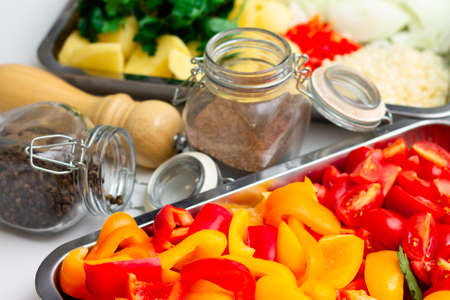 Chopped ingredients for making oriental vegetable stew. Paprika, potatoes, onions, tomatoes, garlic, peppers and spices.の写真素材