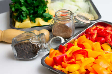 Chopped ingredients for making oriental vegetable stew. Paprika, potatoes, onions, tomatoes, garlic, peppers and spices.の写真素材
