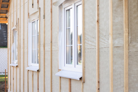 Wall, pediment of a house under construction with windows, vertical beams and a protective membrane, for wall claddingの写真素材