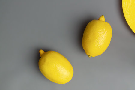 Yellow lemons on gray background. Colors of the Year 2021  Illuminating and Ultimate gray, flat lay, copy spaceの写真素材