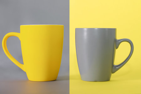 Yellow cup on gray background and gray cup on yellow background. Colors of the Year 2021 Illuminating and Ultimate gray.の写真素材