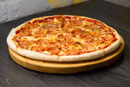 Pepperoni pizza, on round tray on wooden tableの写真素材