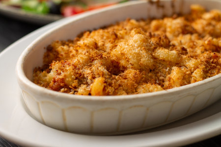 Casserole or lasagna sprinkled with breadcrumbs in white oval ceramic baking dishの写真素材