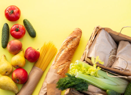 Fresh organic bread, vegetables, greens and fruits, cereals and pasta on a yellow background. Ecological farm food concept. Top view. Flat layの写真素材