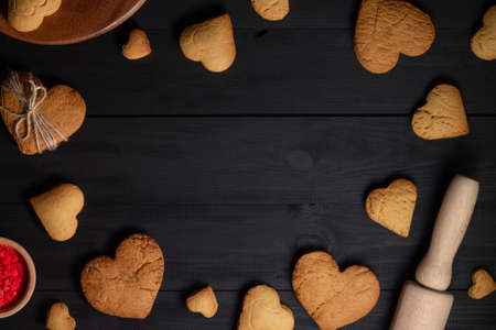Gingerbread cookies and baking supplies on black wood background, copy spaceの写真素材
