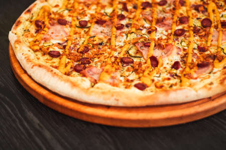 Bavarian pizza, on round tray on wooden tableの写真素材