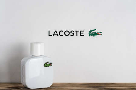 Minsk, Belarus 05/07/2021: White perfume bottle with Lacoste logo on wooden surface on white backgroundのeditorial素材