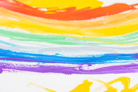 Fragment of children's drawing of rainbow on white sheet of paper. Top view