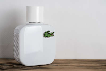 Minsk, Belarus 05/07/2021: White perfume bottle with Lacoste logo on wooden surface on white backgroundのeditorial素材