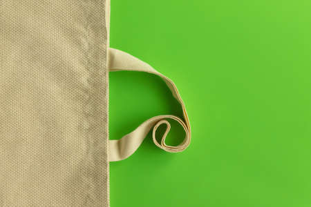 Fabric cotton shopping bag on a green background. Zero waste and ecological concept. Top view, copy space.の写真素材