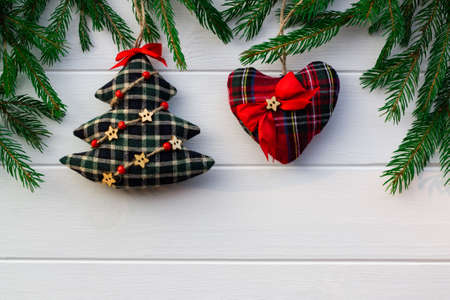 Green branches of a Christmas tree with DIY soft decoration on a background of white boards. Flat lay, copy space.の写真素材