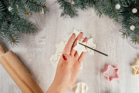 Step-by-step Christmas stars homemade cold porcelain garland tutorial. Step 14: Punch holes for rope or ribbon with drinking straw or stick. Top viewの写真素材