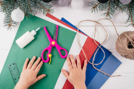 Step-by-step Greeting card 3D Christmas tree tutorial. Step 1: You will need A4 sheets of cardboard and green colored paper, scissors, ruler, glue, rope and other colors of paper. Top viewの写真素材