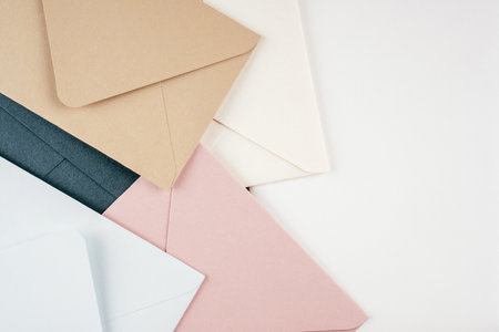 Background image of multi-colored cardboard envelopes lying randomly on white background. Top view....