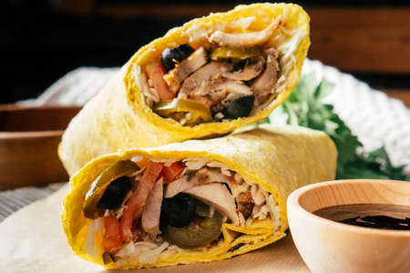 Mexican roll of shawarma with hot sauce, jalapeno pepper, olives, chicken and vegetables in pita...