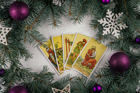 Tarot cards fanned out on white concrete surface with Christmas tree branches and decorations. Minsk, Belarus, 11/19/2021のeditorial素材