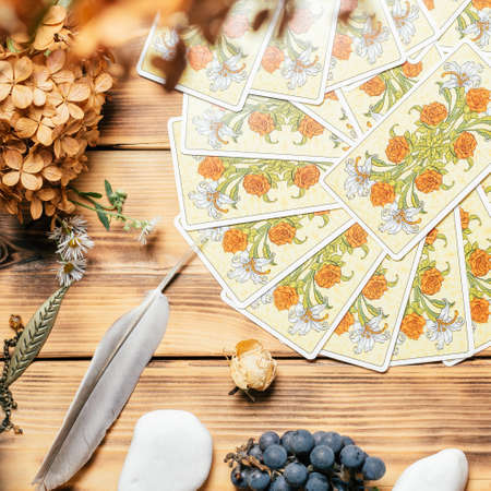 Tarot cards fanned face down on wooden surface with stones, autumn plants and accessories. Top view. Minsk, Belarus, 11.10.2021のeditorial素材