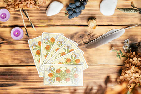 Tarot cards fanned face down on wooden surface with stones, autumn plants and accessories. Top view. Minsk, Belarus, 11.10.2021のeditorial素材
