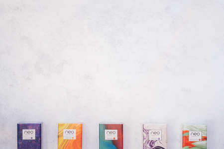Packs of Neo smoking sticks with different flavors on white concrete surface. Cigarettes for use...