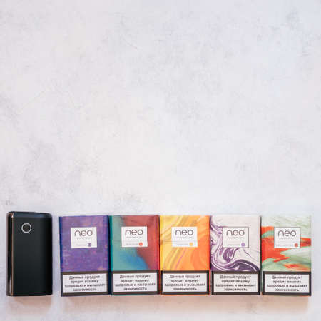 Packs of Neo smoking sticks with different flavors on white concrete surface. Cigarettes for use with Glo heating device. Copy space. Flat lay. Top view. Minsk, Belarus 30.10.2021のeditorial素材