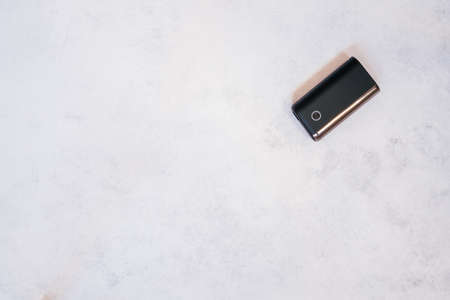 Black new heating smoking device on white concrete surface. Copy space. Flat lay. Top view. Bannerの写真素材