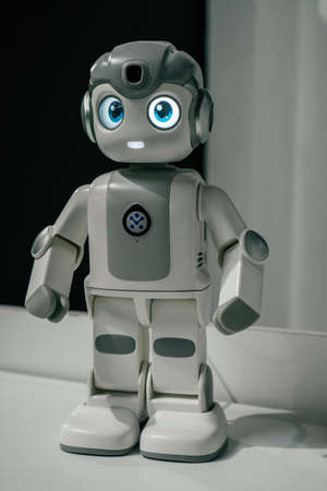 Partially blurred humanoid white robot with glowing blue eyes. Verticalの写真素材