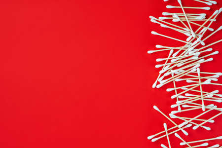 Wooden cotton buds on red background. Hygienic accessory product concept. Environmental conservation concept. Auricle hygiene. Beauty concept. Top view. Flat lay.の写真素材