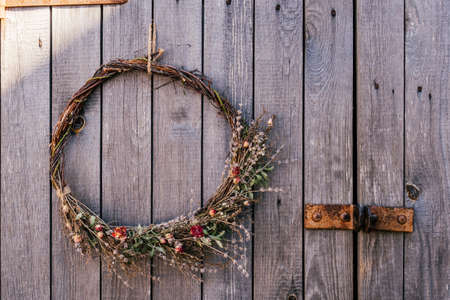 Handmade twisted natural creative dry herbal wreath from twigs of willow, wild and field flowers,...