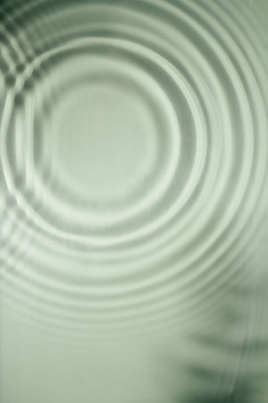 Defocused rippled transparent fresh green water gel surface in pool with flecks, waves, shade. Concentric expanding circles on surface from fallen drop. health care on sea coast. copyspace. Verticalの写真素材