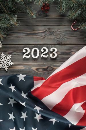 Vertical dark wooden wallpaper with American flag 2023 and Christmas toy frame decoration. Happy new...