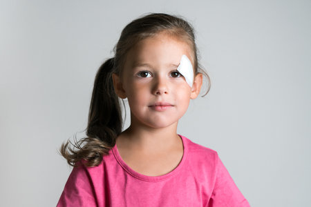 Close up nice, cute, lovely, adorable dark haired little child, girl with bandage covering injury,...