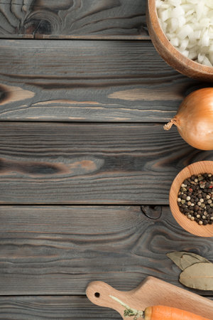 Fragrant flavorings and vegetables. Layout of foodstuffs on kitchen wooden table. Planking, place for text, flat lay. Onion, peppercorns and carrots. Prepare ingredients for cooking. healthy diet.の写真素材