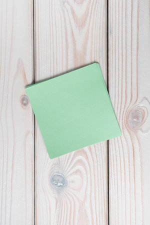 Flat lay of empty blank green sticker sticky note on grey wooden table. Note, paper, reminder,...
