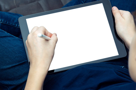 Unrecognizable male hands drawing with stylus pen on digital tab, pad touchscreen with white screen...