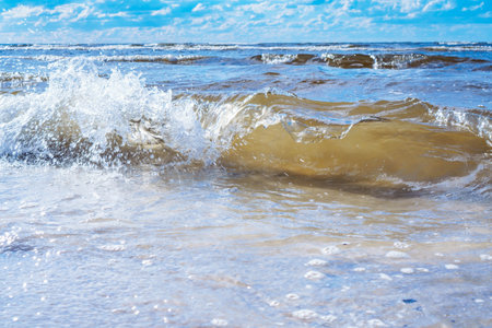 Close-up of blue water, foamy waves of sea ocean on windy day. Sun rays reflecting on waves. Summer, holidays, seascape, vacation, coastline, seashore, seaside, travelling, tourism, nature, storm.の写真素材