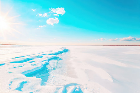 A serene frozen lake showcases melting ice formations under vibrant sunlight. The clear blue sky complements the stunning winter landscape creating a peaceful ambiance perfect for reflection.の素材