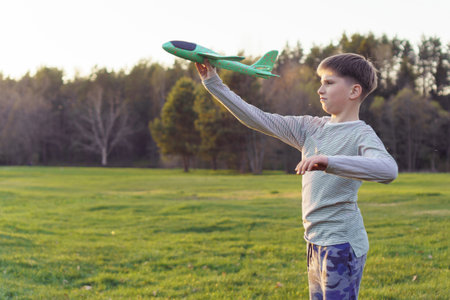 Teenage aircraft modeler launches his model airplane at aerial competitions. Active outdoor games. Holidays and weekends. Hobbies and happy childhood.の写真素材