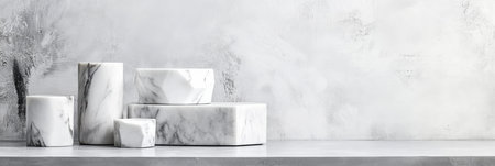A collection of marble geometric sculptures rests on a smooth metal surface with soft lighting illuminating their intricate details. The backdrop features clean copy space enhancing the aesthetic.の素材
