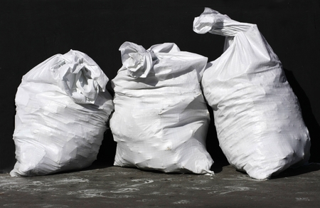 three bags of white on a black background with traces of shoesの写真素材