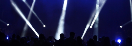 Dark blue stage lights crisscrossed the stage spotlights and black shadows of people